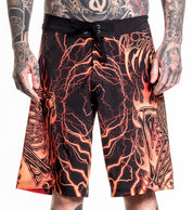Infernal Nightmare Boardshort with fiery skeleton design, 92% polyester 8% spandex, model wearing size 32.