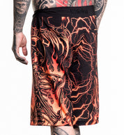 Infernal Nightmare Boardshort featuring fiery skeleton and lightning design with 4-way stretch fabric in size 32 worn by tattooed model.