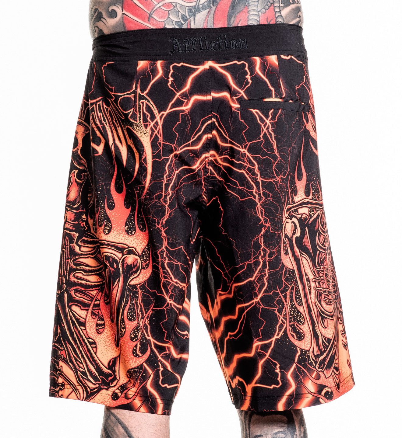 Infernal Nightmare Boardshort in black and orange with neon lightning and skeleton flame design, size 32 worn by model.