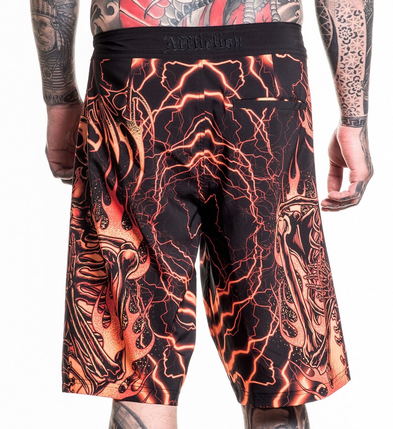 Infernal Nightmare Boardshort with fiery skeleton and lightning design, 92% polyester 8% spandex, model wearing size 32.