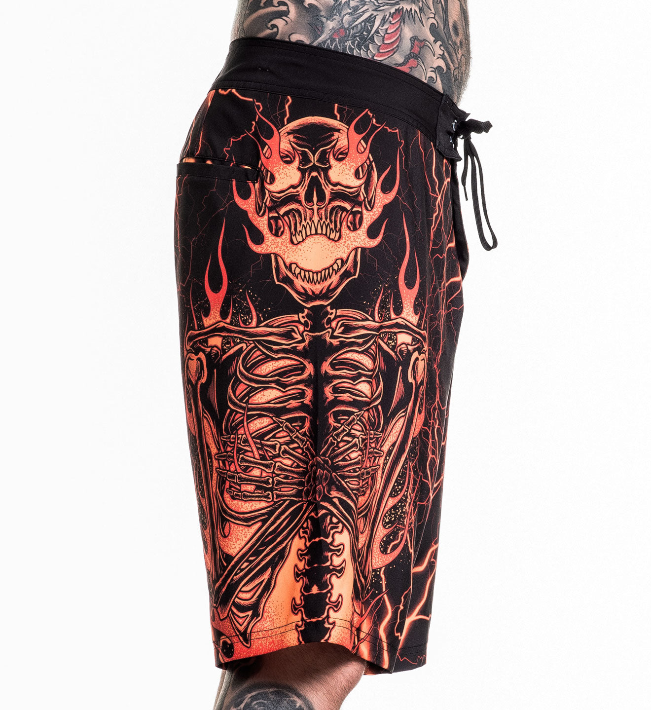 Infernal Nightmare Boardshort featuring fiery skeleton design, 92% polyester, 8% spandex, 4-way stretch fabric, size 32 model.